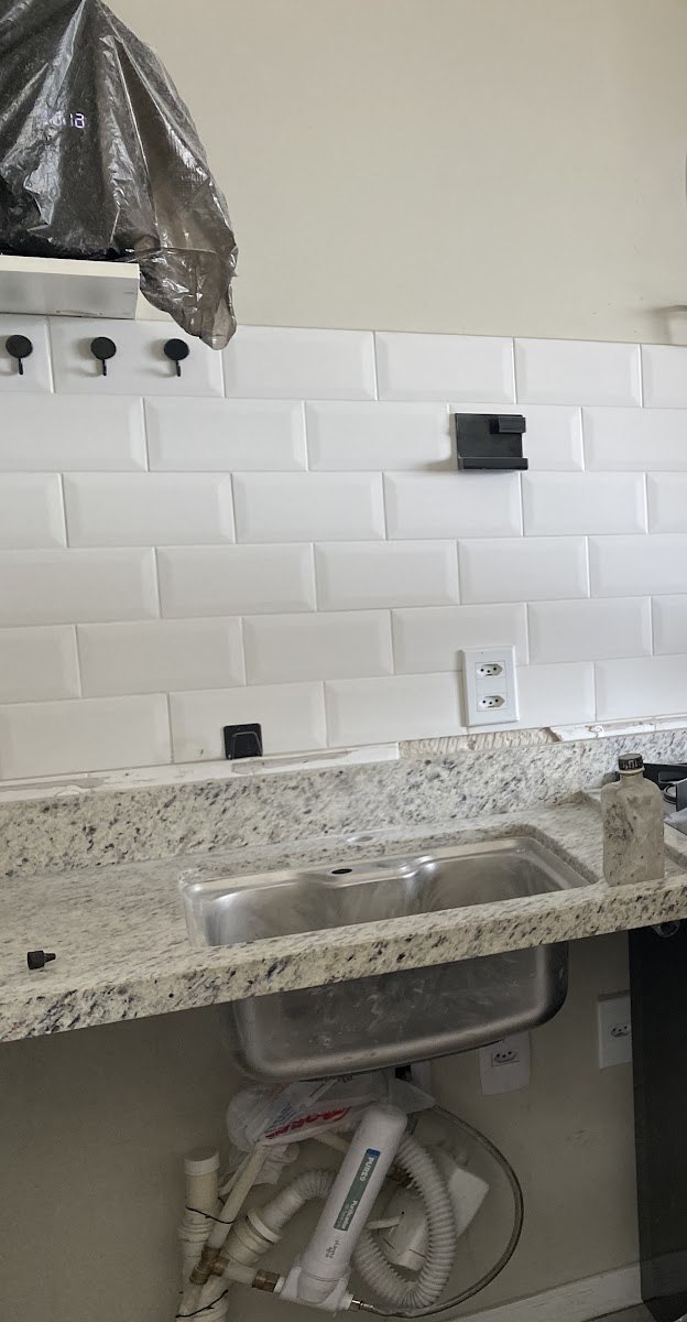 Bancada de granito claro instalada com cuba de inox