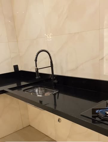 Bancada de granito preto com cuba de inox e torneira gourmet