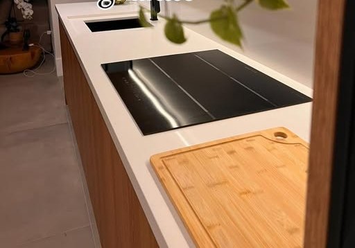 Bancada clara com cooktop embutido e recorte para cuba